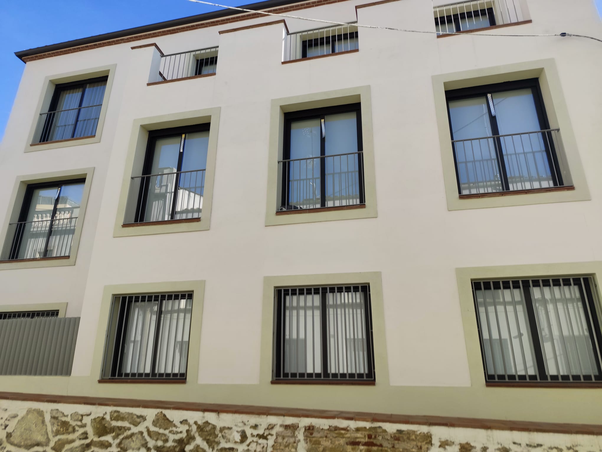 Façana d’un edifici a Badalona amb reixes i baranes metàl·liques instal·lades