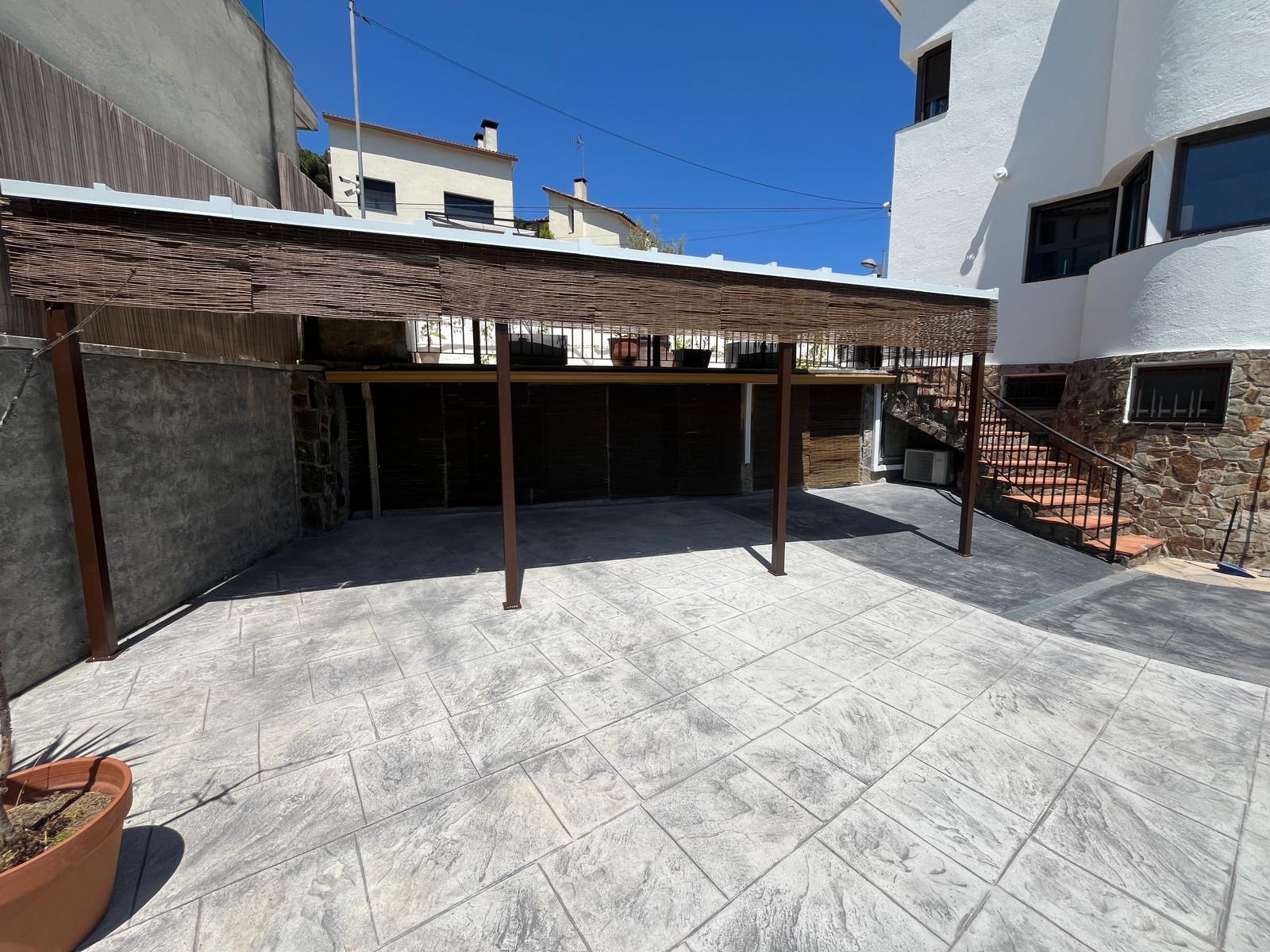 Pèrgola metàl·lica a mida instal·lada en un pati exterior d’un habitatge