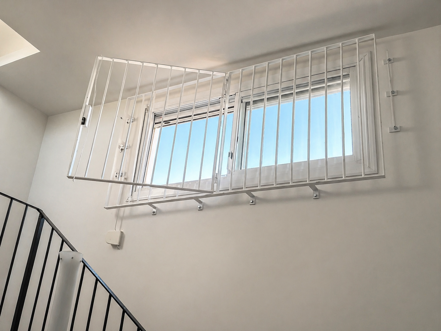 Reixa metàl·lica abatible instal·lada en una finestra interior d’un habitatge